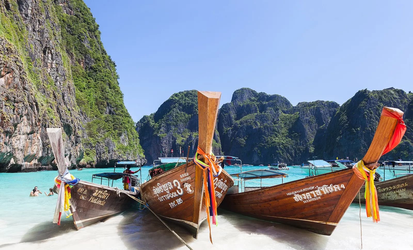 Photo: Diego Delso, CC BY-SA 3.0 Longtail boats at Maya Bay, Ko Phi Phi, Thailand